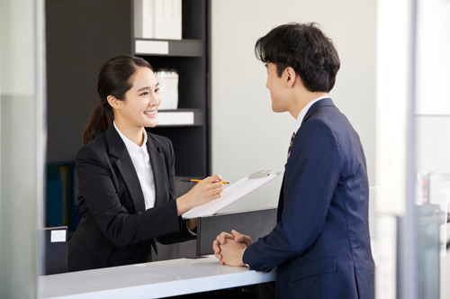 A secretary handling documents with a businessman