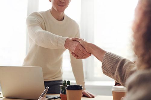 A man and a woman shake hands to mark a successful deal
